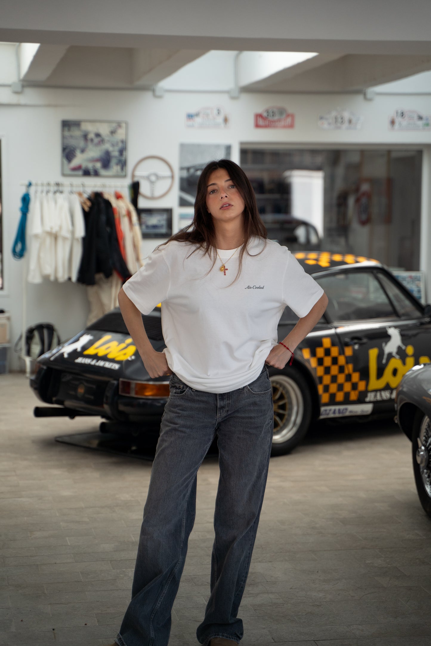 woman wearing a white t-shirt with a logo in a garage setting