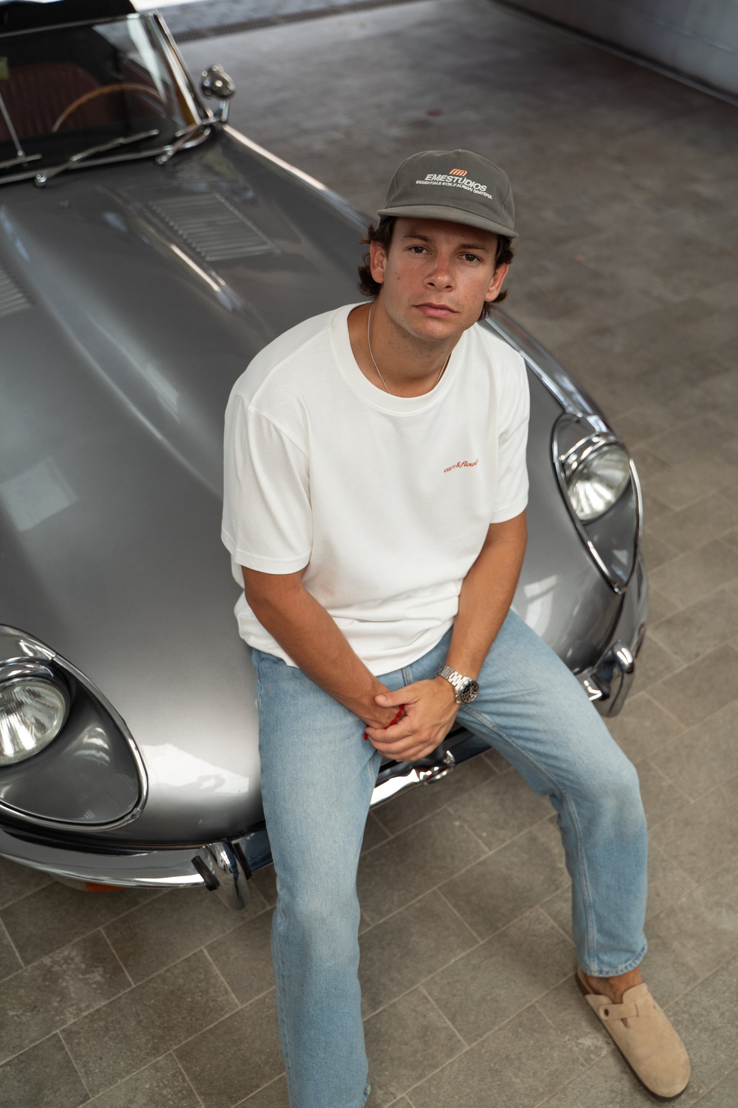 Man sitting in front of a Jaguar e-type