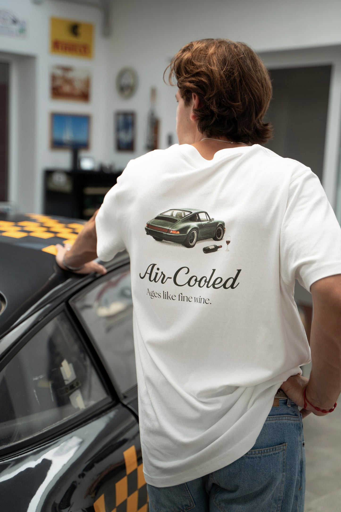 Person wearing a white t-shirt with a classic Porsche 911 design, with Air-cooled text.