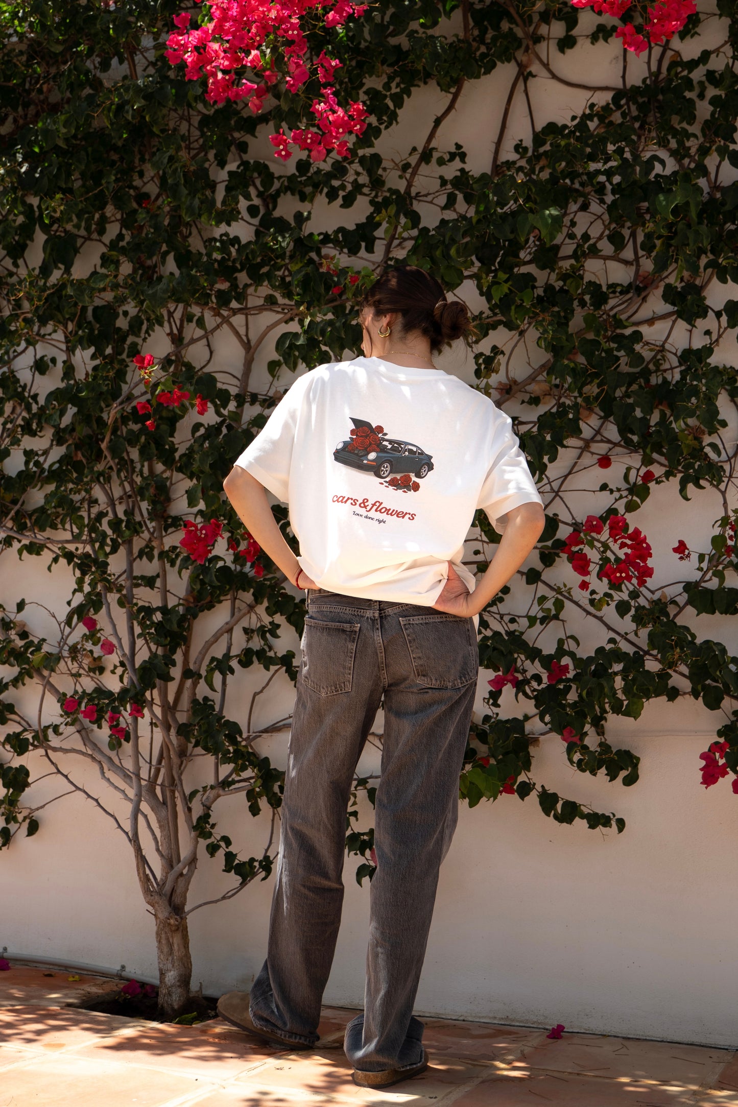 Model wearing a white t-shirt with a classic Porsche 911 design and flowers