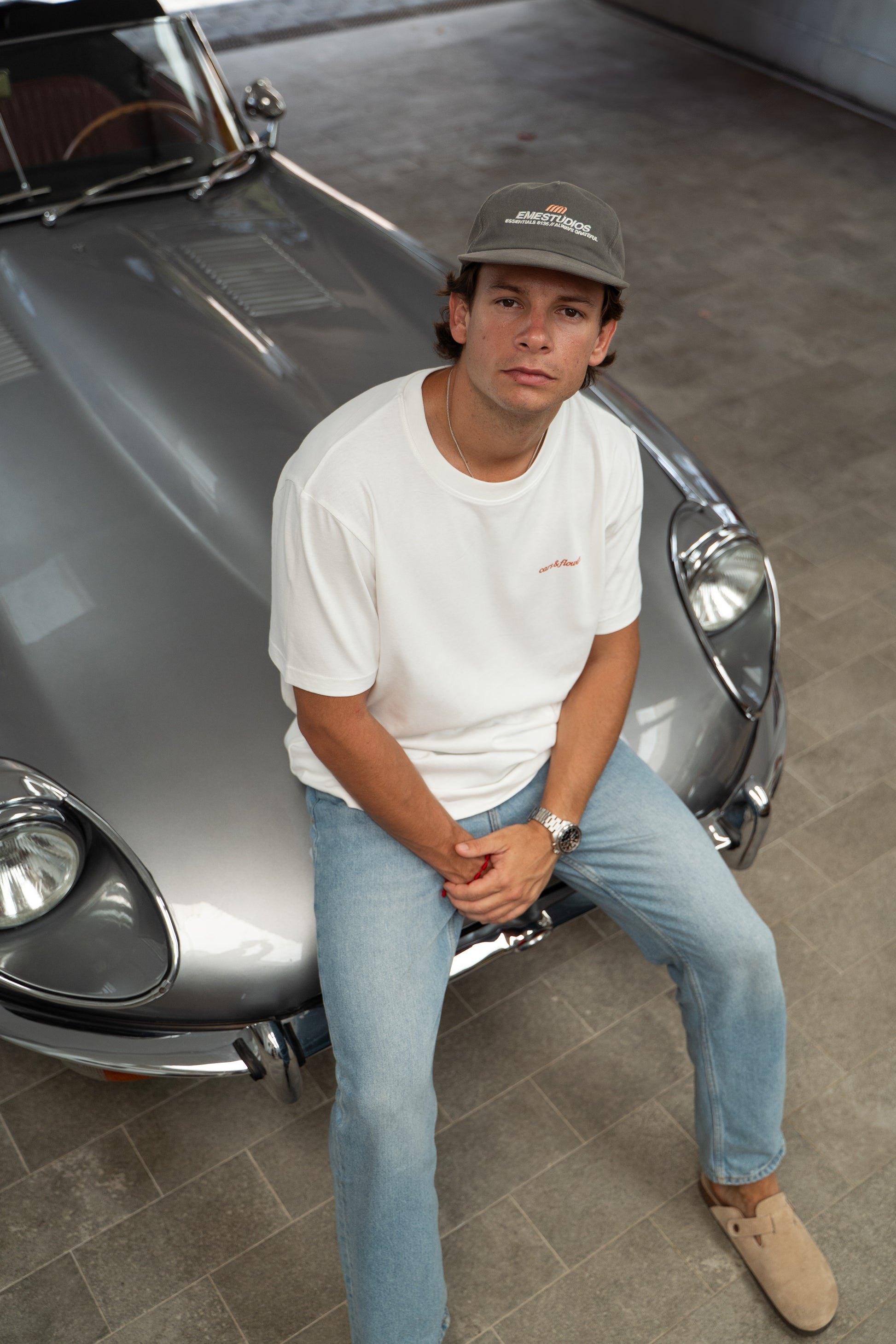 Man sitting in front of a Jaguar e-type