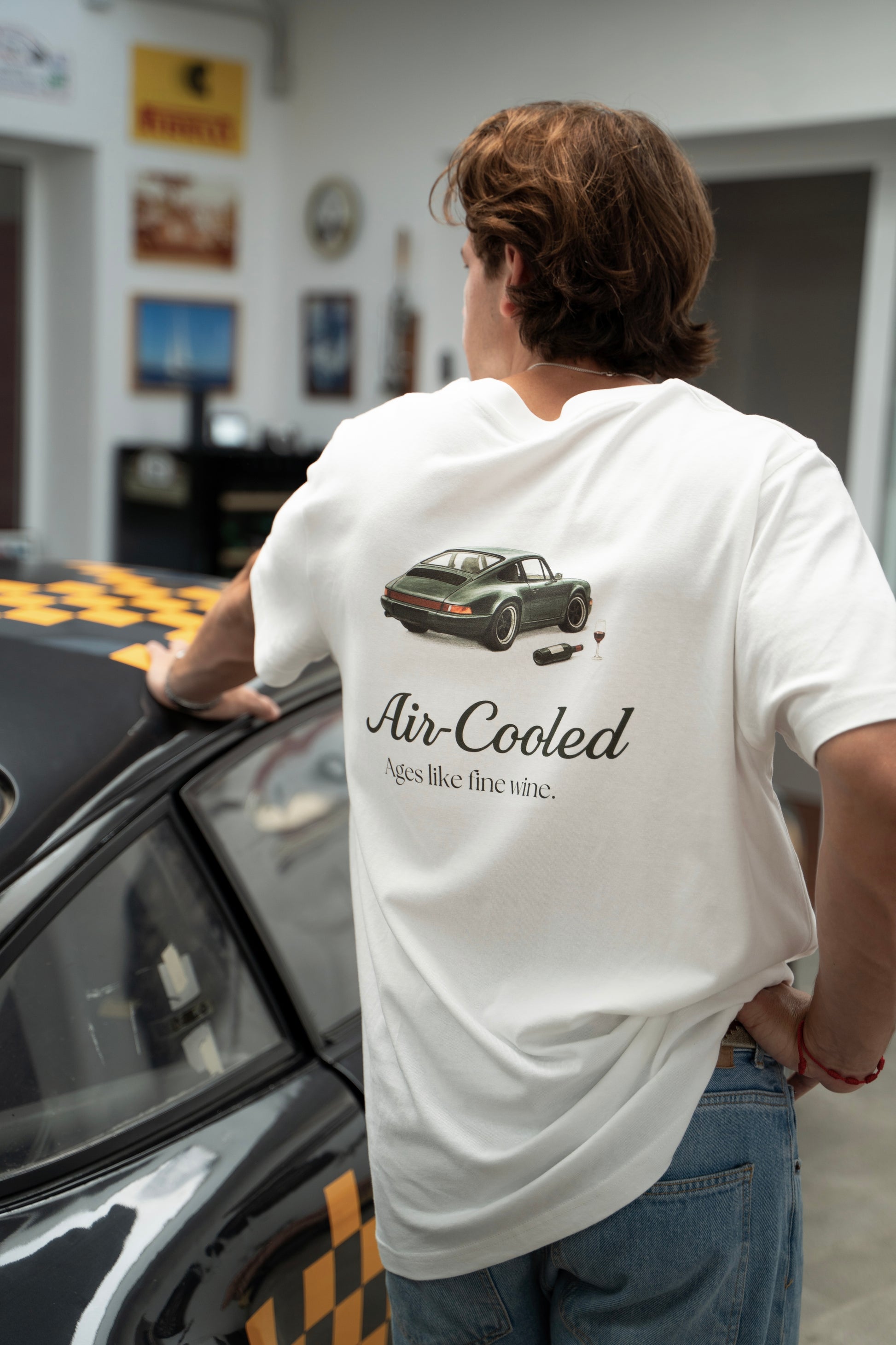 Person wearing a white t-shirt with a classic Porsche 911 design, with Air-cooled text.