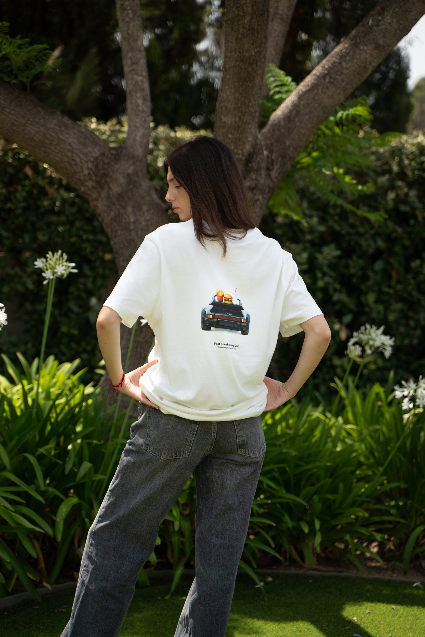 woman wearing a white t-shirt with a porsche 911 design outdoors